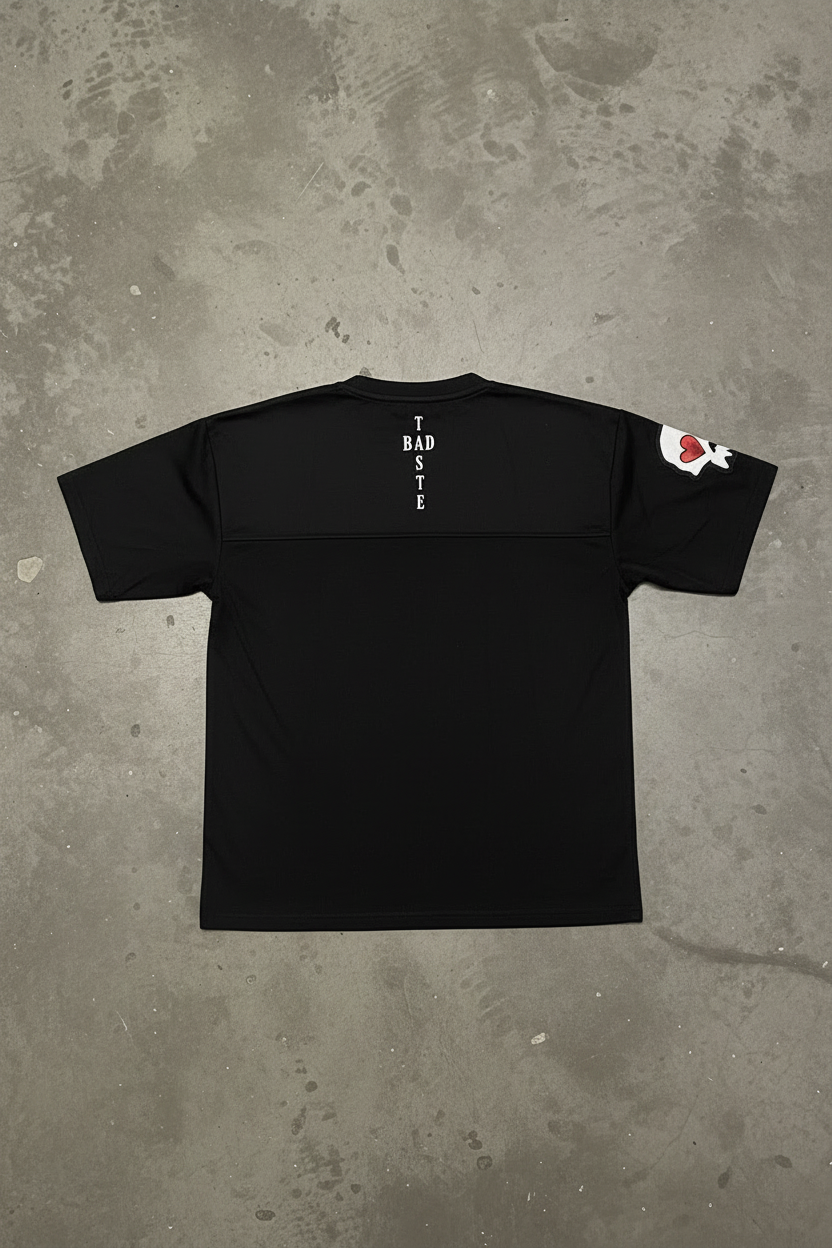 BADTASTE Black Tee Back on Concrete