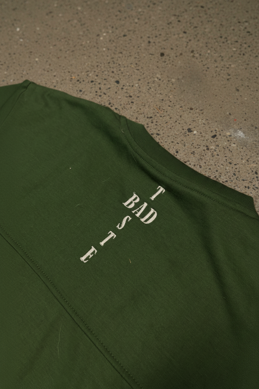 BADTASTE Green Tee Detail on Concrete